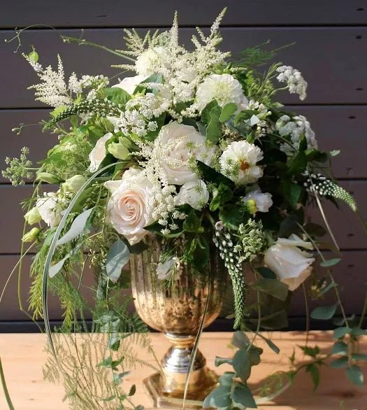 Elegant funeral bouquet with white roses, dahlias, astilbe, and cascading greenery in a gold urn vase – sophisticated floral tribute for funerals and memorial services.